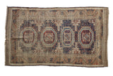 Antique Belouch rug, quadruple medallion tribal geometric design, dark chestnut, navy, tobacco tones.
