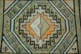 Geometric tribal triple medallion design on a vintage Caucasian rug in ivory, charcoal, orange.
