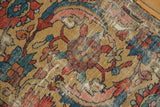 Close-up of worn gold field, expressive red and blue serrated leaf design.