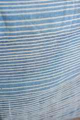Close-up of handwoven indigo pillow textile with subtle thin white stripes.