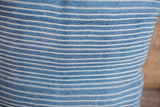 Fine handwoven texture of the indigo blue textile with subtle white stripes.