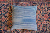 Vintage indigo throw pillow showcasing subtle white stripes and handwoven textile variations.