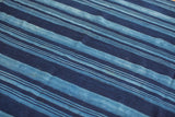 Hand woven texture of the indigo blue striped textile with subtle dye variations.