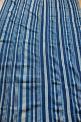 Varied indigo blue stripes and handwoven texture on vintage African cotton textile.