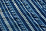 Hand-woven indigo striped textile with varying blue shades and subtle vintage character.