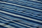 Vintage indigo striped textile with varying blue hues and hand-woven texture.