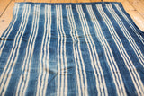 Hand-woven vintage indigo textile featuring varied blue and natural cream stripes.
