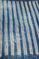 Collectible hand-woven indigo textile with varying blue and cream striped pattern.