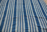 Hand-woven indigo blue striped cotton textile with varied stripe widths and vintage texture.