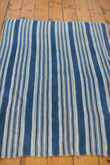 Angled view of the hand-woven vintage indigo blue striped textile with varying stripe widths.