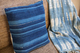 Dark blue striped indigo pillow with varied shades and hand-woven texture.