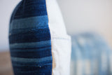 Indigo striped pillow side with woven blue textile and stitched white canvas.