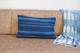 Dark blue striped indigo lumbar pillow featuring finely woven texture and varying shades.