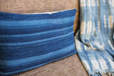 Dark blue indigo lumbar pillow featuring strong horizontal stripes and woven texture.