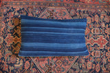 Dark blue indigo lumbar pillow with varied handwoven stripes and aged texture.