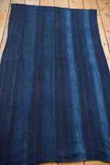 Hand-woven collectible indigo blue textile with variegated stripes and subtle texture.
