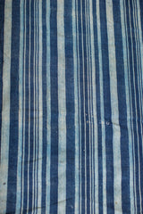 Collectible hand woven indigo textile showing varied blue striped texture.