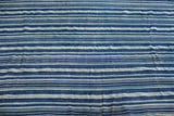 Hand-woven indigo blue striped textile detail, revealing subtle variations and texture.