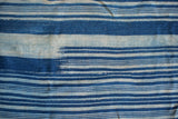 Textured handwoven vintage indigo textile with rich and light blue horizontal stripes.