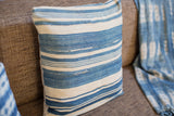 Light indigo striped throw pillow showcasing handwoven texture and subtle mended details.