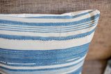 Light indigo striped pillow corner detail, showing finely woven texture and storied repair stitching.