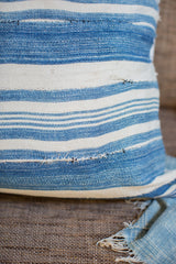Vintage indigo striped pillow, close-up of handwoven texture and visible storied repairs.