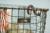 Mid century wire basket close-up, showing rusted number tag and top hook.