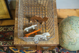 Silvery Fred Medart gym locker wire basket, overhead view, filled with colorful wooden toys.