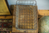 Aged galvanized wire basket grid showing hints of old blue paint.