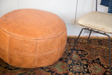 Camel brown Moroccan leather pouf with stenciled flower fan and fleur de lis designs.
