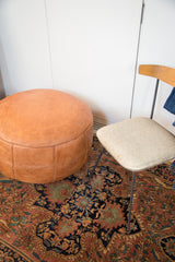Camel brown leather Moroccan pouf with fleur de lis and flower fan stenciling.