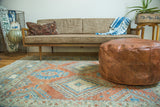 Natural brown antique revival leather pouf, featuring fleur de lis stenciling.