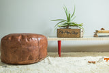 Antique Revival natural brown Moroccan leather pouf with stenciled fleur de lis and flower fan motifs.