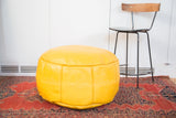 Fly yellow Moroccan leather pouf with stenciled fleur de lis and flower fan motifs.
