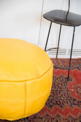 Embossed fleur de lis and floral fan patterns on the Fly Yellow leather pouf.