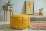 Antique Revival extra large mustard yellow leather pouf with embossed floral patterns, 16x28 inches.