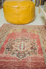 Mustard yellow leather pouf showing subtle decorative stenciling detail.