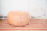 Antique Revival nude Moroccan leather pouf ottoman with floral stenciling, 16x28 inches.
