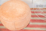 Nude Moroccan leather pouf detail, highlighting stenciled floral pattern and rich texture.