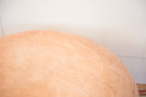 Embossed flower fan stenciling and distressed texture on nude leather pouf.
