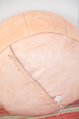 Nude leather pouf bottom lacing with distressed texture and stenciled motif.