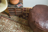 Antique Revival whiskey brown leather pouf with embossed flower fan motifs.