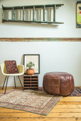 Whiskey brown antique revival leather pouf with subtle stenciling and rich texture.