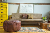 Antique Revival whiskey brown leather pouf with distressed fleur de lis stenciling.