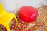 Cherry red Moroccan pouf ottoman featuring fleur de lis and flower fan stenciling.