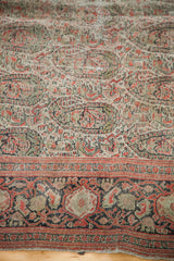 Distressed field with repeating boteh and a muted geometric border of this antique Senneh rug.