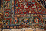 Antique Qashqai rug corner with rich jewel-tone stylized motifs and fringe.