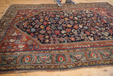 Detailed border of antique Qashqai rug, displaying jewel-tone geometric patterns and some edge wear.