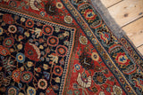 Antique Qashqai rug corner showcasing worn pile, vivid jewel-toned motifs, and edge mesh.