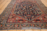Hand-knotted antique Qashqai rug corner, featuring intricate jewel-toned patterns.